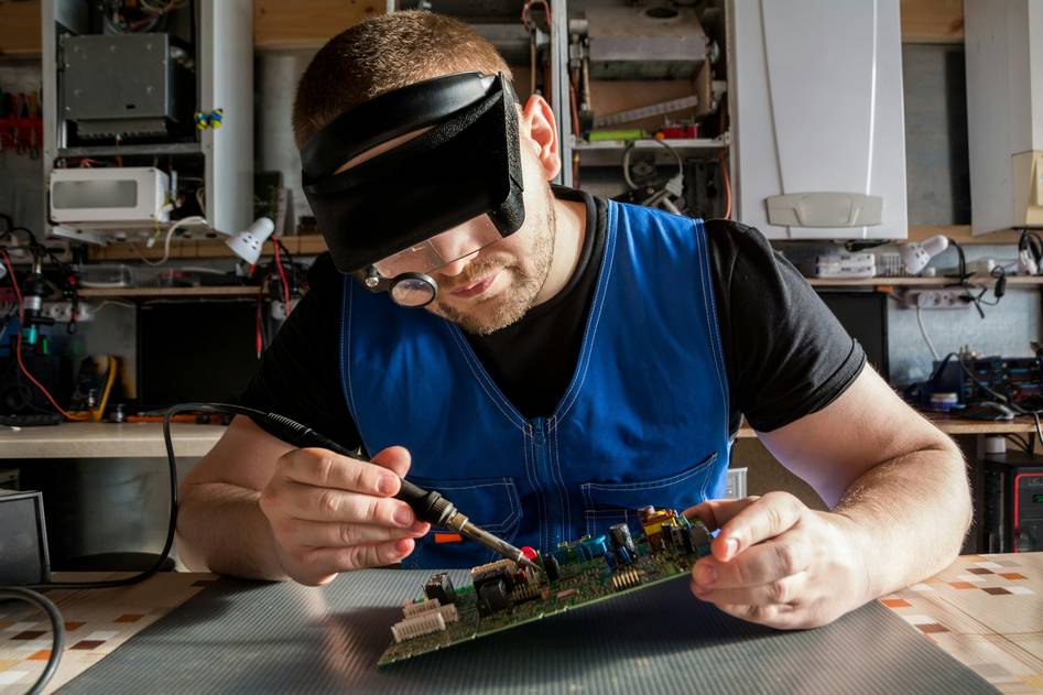 Engineer debugging embedded code on laptop with logic analyzer